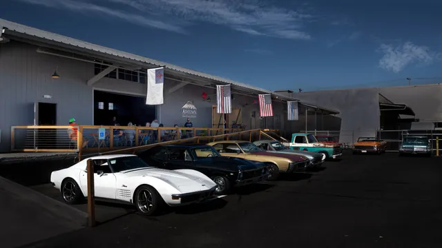 A white Corvette and a row of classic cars outside Ashtown
